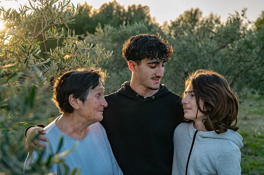 Photo de famille une grand-maman et ses deux petits fils dans les oliviers